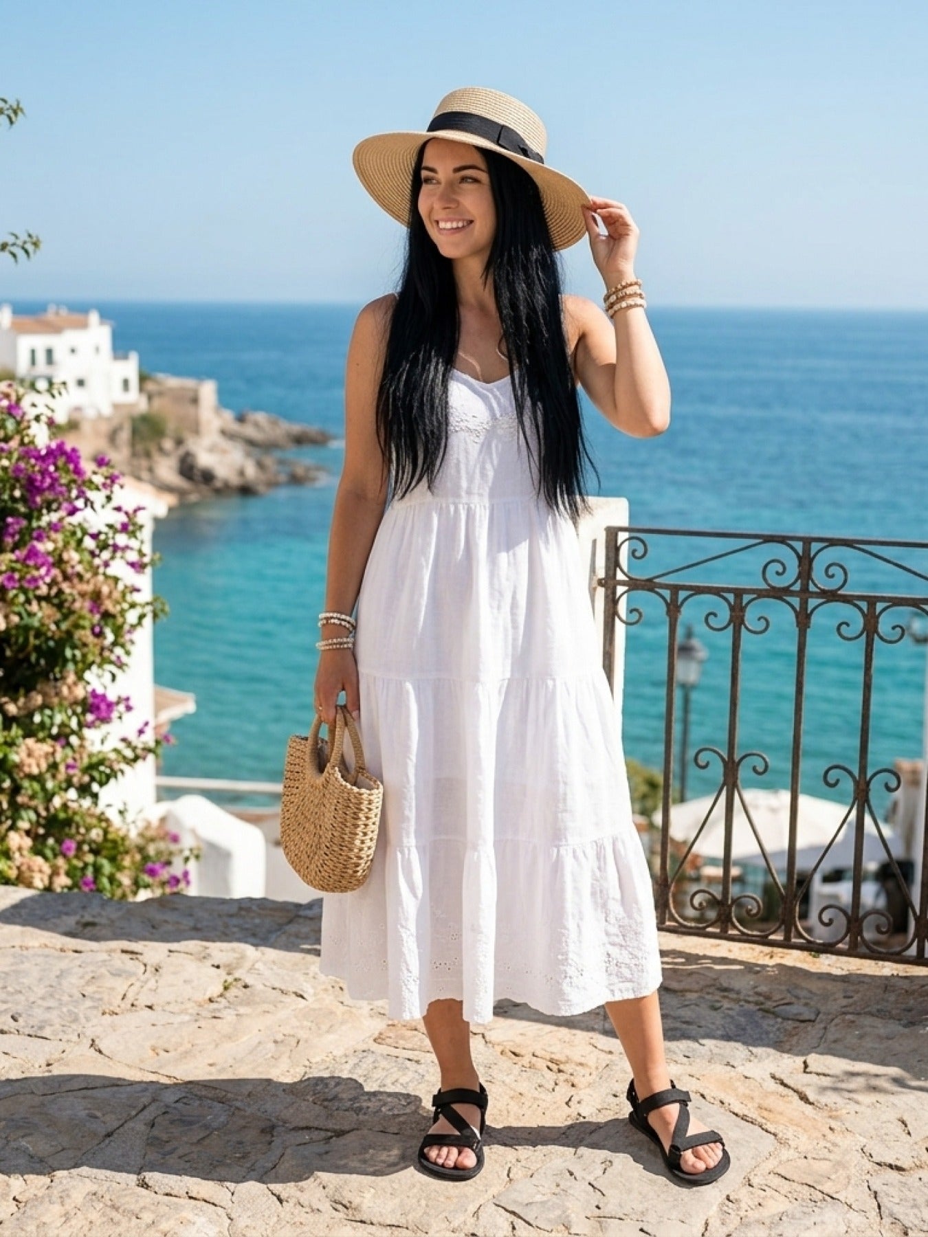 Mujer sonriente con vestido blanco, sombrero de paja y sandalias barefoot Be Lenka Flexi 2.0 negras.